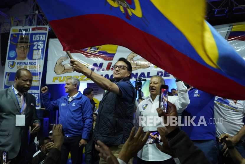 Kandidat presiden Fernando Villavicencio mengibarkan bendera nasional Ekuador saat kampanye di sebuah sekolah beberapa menit sebelum dia ditembak mati di luar sekolah di Quito, Ekuador, Rabu, (9/8/2023).