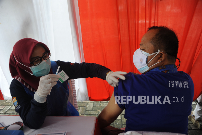 Petugas menyuntikkan vaksin ke salah satu pekerja pada vaksin untuk pekerja dan lansia di halaman DPRD Provinsi Sumsel Palembang, Sumsel, Sabtu (1/5/2021). Polda Sumsel bersama Dinas Kesehatan Provinsi Sumsel menggelar vaksin bagi pekerja dan lansia dalam rangka hari buruh 1 Mei. 