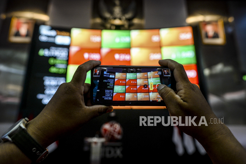 Karyawan memotret layar Pergerakan Indeks Harga Saham Gabungan (IHSG) di Bursa Efek Indonesia, Jakarta.