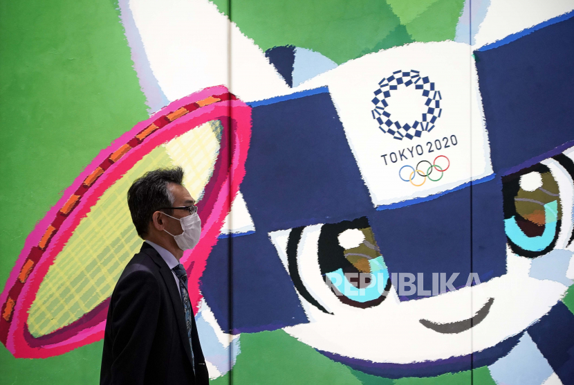  Seorang pria berjalan melewati papan iklan Olimpiade Tokyo di Tokyo, Jepang, 27 Januari 2021. Komite Olimpiade Internasional akan mengadakan pertemuan Dewan Eksekutif mengenai Olimpiade Tokyo yang dijadwalkan ulang untuk dibuka pada 23 Juli 2021. 
