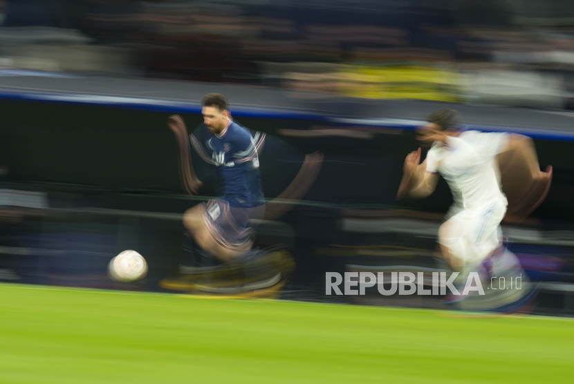 Pemain PSG Lionel Messi, berbaju biru, berlari dengan bola selama pertandingan sepak bola leg kedua babak 16 besar Liga Champions antara Real Madrid dan Paris Saint-Germain di stadion Santiago Bernabeu di Madrid, Spanyol, Kamis (10/3/2022).