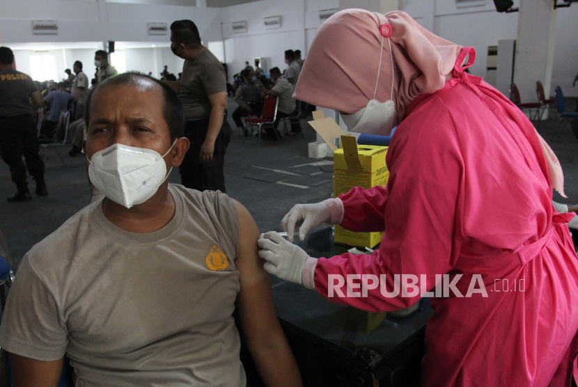 Petugas kesehatan menyuntikan vaksin COVID-19 kepada seorang anggota kepolisian di Polrestabes Surabaya, Jawa Timur, Selasa (23/2/2021). Vaksinasi COVID-19 yang digelar selama tiga hari itu diikuti seluruh anggota kepolisian dan Aparatur Sipil Negara Polrestabes Surabaya sebagai upaya penanggulangan pandemi COVID-19. 