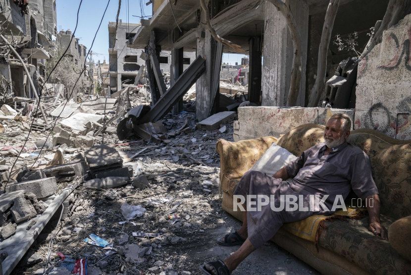  Mofeed Sabit, 64, duduk di sofa di sepanjang jalan yang dipenuhi puing-puing, dari serangan udara yang menghancurkan sebuah bangunan sebelum gencatan senjata yang dicapai setelah perang 11 hari antara penguasa Hamas di Gaza dan Israel, Senin, 24 Mei 2021, di Magazzi, Jalur Gaza. 