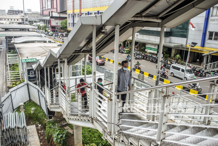 Calon penumpang Transjakarta berjalan di Halte Glodok, Jakarta, Jumat (14/1/2022). PT MRT Jakarta (Perseroda) akan membongkar Halte TransJakarta Glodok untuk persiapan pekerjaan konstruksi proyek MRT Jakarta Fase 2A. 