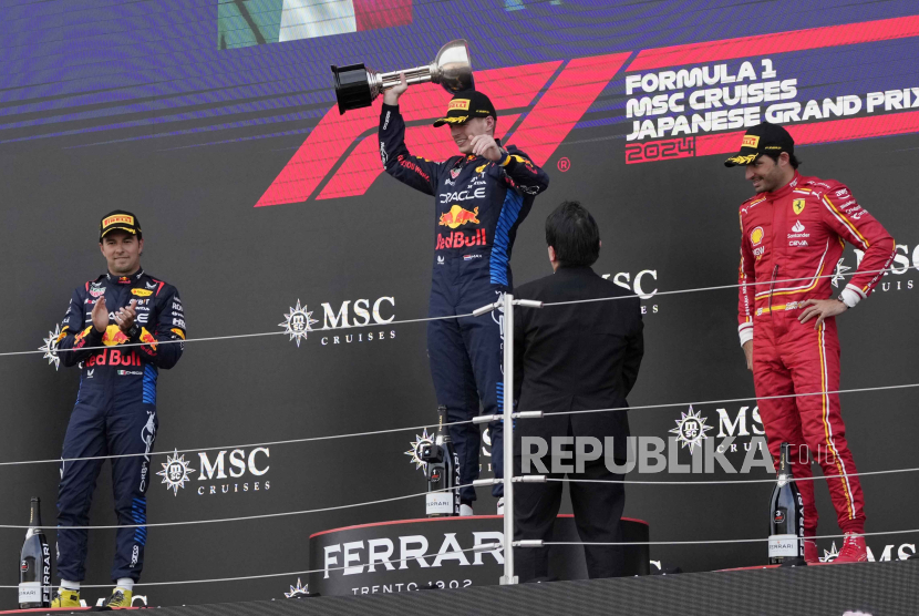 Red Bull driver Max Verstappen, center, celebrates on the podium after winning the Japanese Formula One Grand Prix at the Suzuka Circuit in Suzuka, central Japan, Sunday, April 7, 2024.Red Second placed Bull driver Sergio Perez. left, of Mexico, and third place was Ferrari driver Carlos Sainz of Spain.  