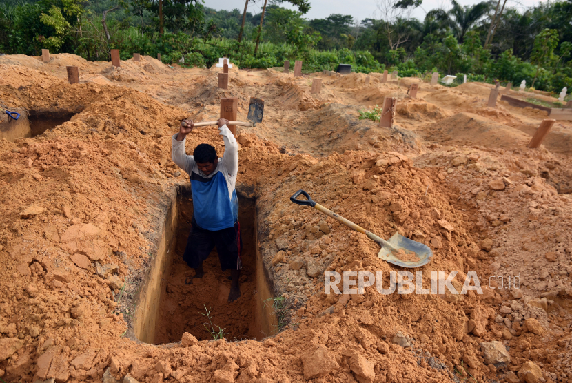 Seorang penggali kuburan menyiapkan liang lahat (ilustrasi).