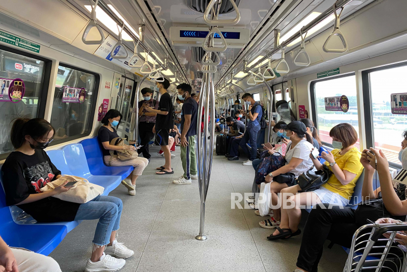 Para penumpang memakai masker dan mempraktikkan jarak sosial saat berada di dalam kereta bawah tanah pada Rabu, 19 Mei 2021 di Singapura. Singapura akan menghapus persyaratan wajib masker di dalam ruangan mulai 29 Agustus mendatang. 