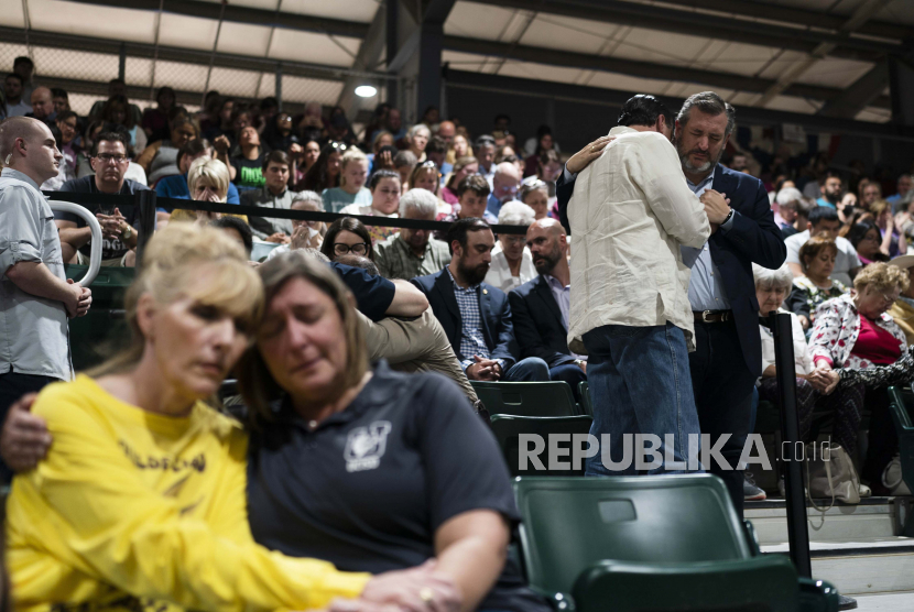 Senator Ted Cruz, R-Texas, paling kanan, berdoa dengan seorang pria dalam doa bersama di Uvalde, Texas, Rabu, 25 Mei 2022. Peringatan itu diadakan untuk menghormati para korban yang tewas dalam penembakan hari Selasa di Sekolah Dasar Robb.