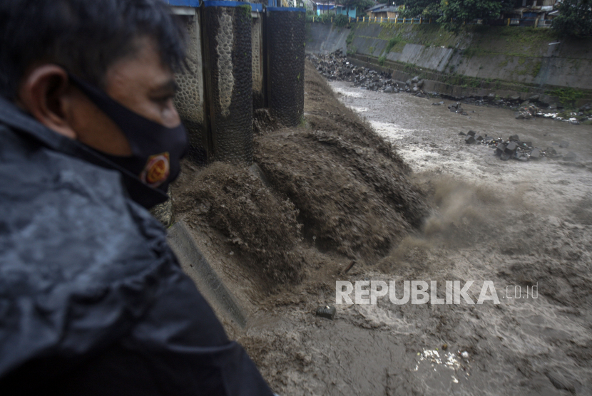 Warga mengamati aliran sungai Ciliwung yang keruh di Bendungan Katulampa ,Kota Bogor, Jawa Barat, Selasa (19/1/2021). Kondisi air sungai Ciliwung menghitam karena bercampur dengan material bekas longsor dan banjir di kawasan Puncak. 