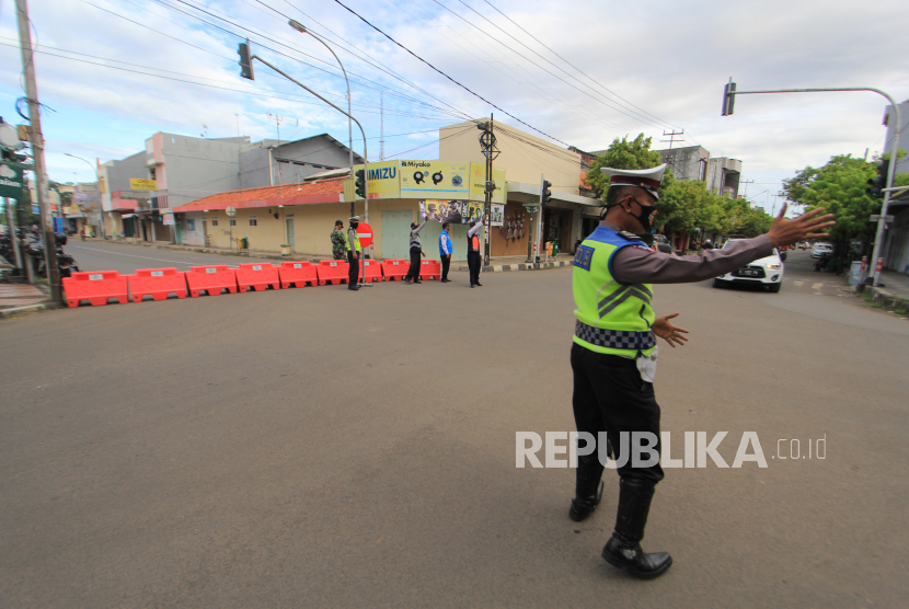 Sejumlah petugas berjaga di jalan DI. Panjaitan yang ditutup di Indramayu, Jawa Barat, Ahad (10/5/2020)