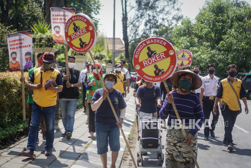 Petugas Dinas Kesehatan dan Dinas Perdagangan berkeliling pasar dengan membawa poster himbauan untuk mengenakan masker saat kegiatan Ronda Masker di Pasar Legi, Solo, Jawa Tengah, Jumat (18/9/2020). Ronda masker tersebut untuk himbauan pedagang sekaligus pengunjung untuk selalu mengenakan masker dan mematuhi protokol kesehatan saat beraktifitas di dalam pasar untuk mencegah penularan COVID-19. 