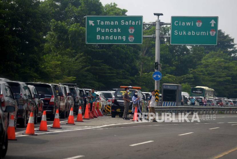 Pengendara keluar dari kendaraanya ketika terjebak kemacetan di Ruas Tol Jagorawi di kawasan Ciawi arah Puncak, Kabupaten Bogor, Jawa Barat, Jumat (6/5/2022). 