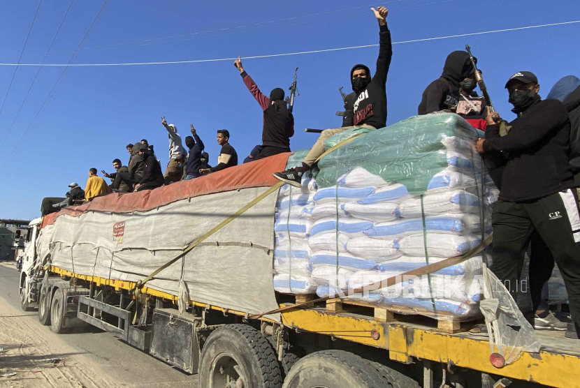 Pejuang Hamas menaiki truk bantuan kemanusiaan di Rafah, Jalur Gaza, Selasa, 19 Desember 2023.