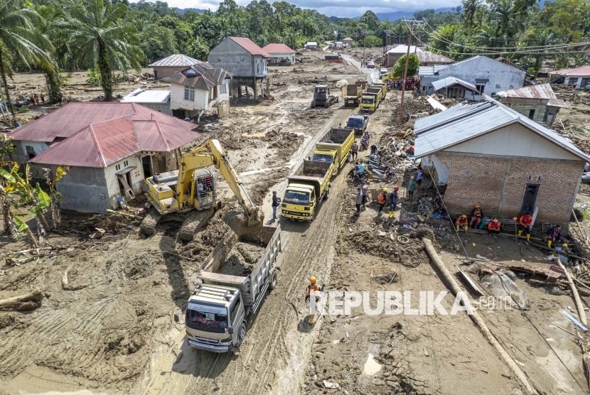 Alat berat membersihkan reruntuhan rumah, kayu, dan lumpur sisa bencana banjir bandang ke atas truk yang mengantre di Jorong Kayu Pasak, Nagari Salareh Aia, Palembayan, Agam, Sumatera Barat, Selasa (9/12/2025). Pemerintah mengerahkan beberapa unit alat berat untuk membersihkan kawasan permukiman dan jalan yang tertimbun runtuhan rumah, kayu, dan lumpur guna mempercepat proses pemulihan kawasan tersebut dan sekaligus mempermudah pencarian korban yang diduga masih tertimbun. 