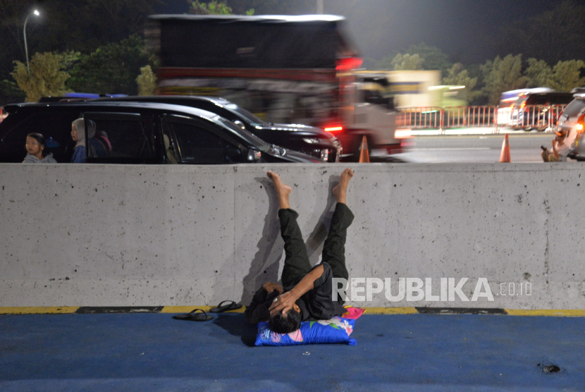 Pemudik beristirahat di bahu jalan tol di kawasan Gerbang Tol Cikampek Utama, Jawa Barat, Sabtu (6/4/2024) dini hari. Dokter menyarankan tidak berkendara selama delapan jam untuk Cegah kelelahan otot.