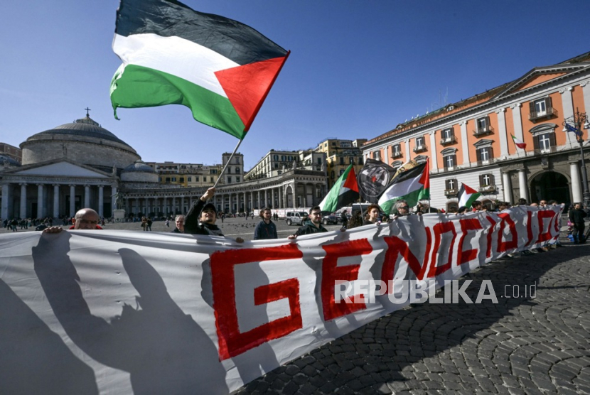 Aktivis Jaringan untuk Gaza membentangkan spanduk sepanjang dua puluh meter dengan tulisan Hentikan Genosida dan selusin paket berdarah yang mewakili bantuan Gaza, dalam protes terhadap apa yang mereka sebut Kekerasan genosida Israel, di Piazza Plebiscito di pusat Naples, Italia, Ahad (3/3/2024).
