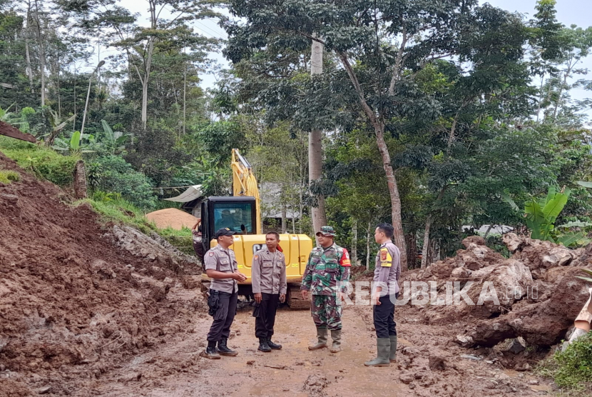 Petugas berupaya mengevakuasi material longsor yang menutup akses jalur Tasikmalaya-Pangandaran di wilayah Desa Cisarua, Kecamatan Cineam, Kabupaten Tasikmalaya, Jawa Barat, Kamis (4/5/2023). 
