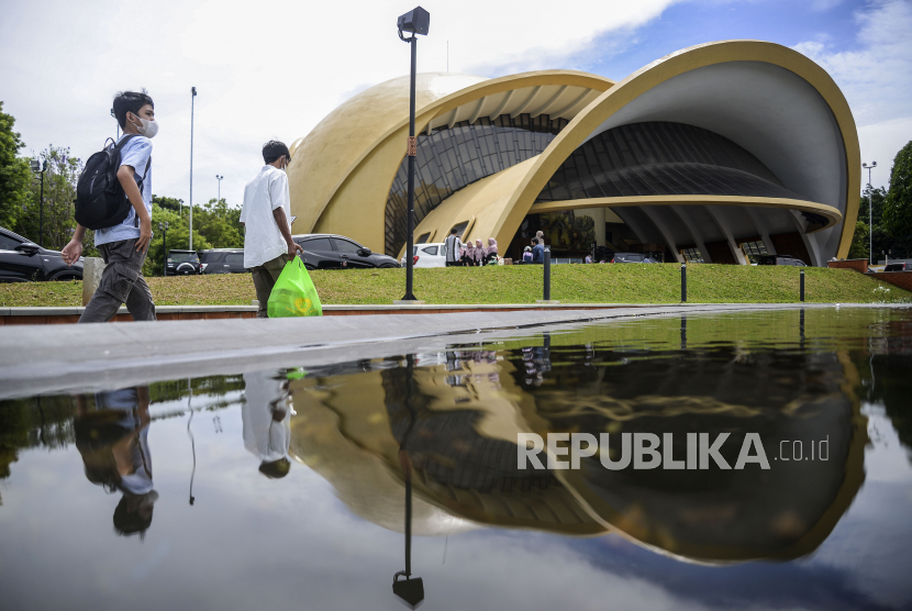 Pengunjung berjalan di area Teater Keong Mas di Taman Mini Indonesia Indah (TMII), Jakarta. Pemkot Jaktim akan menambah kantong parkir kendaraan di TMII saat malam tahun baru.