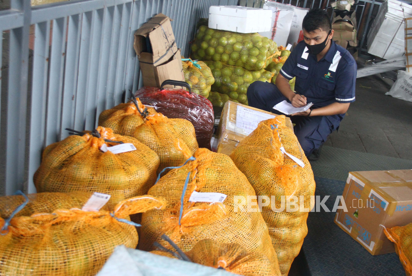 Pekerja mencatat kiriman buah jeruk di gudang jasa pengiriman barang. (ilustrasi) 