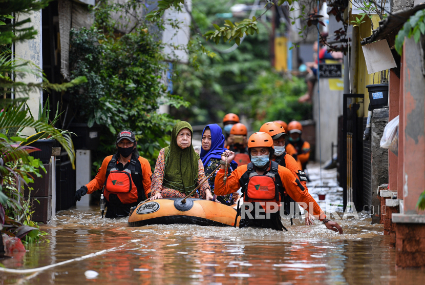 Relawan dari Dompet Dhuafa mengevakuasi warga yang terjebak banjir di Cipinang Melayu, Jakarta Timur, Jumat (19/2/2021). Banjir di kawasan tersebut akibat curah hujan yang tinggi dan meluapnya air dari Kali Sunter. 