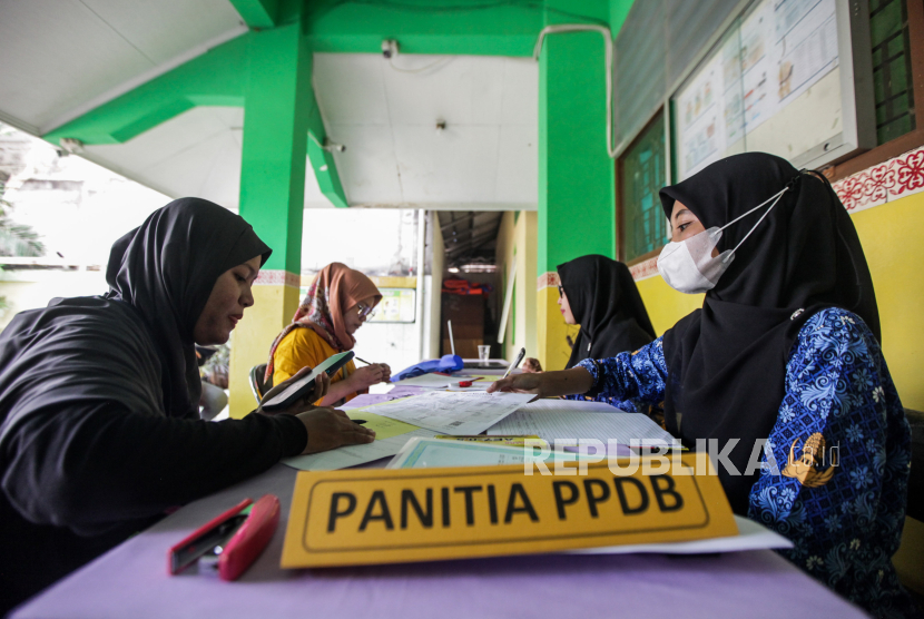 Guru melayani orang tua murid mengajukan pembuatan akun Penerimaan Peserta Didik Baru (PPDB) di SD Grogol Selatan 08, Kebayoran Lama, Jakarta, Senin (20/5/2024).