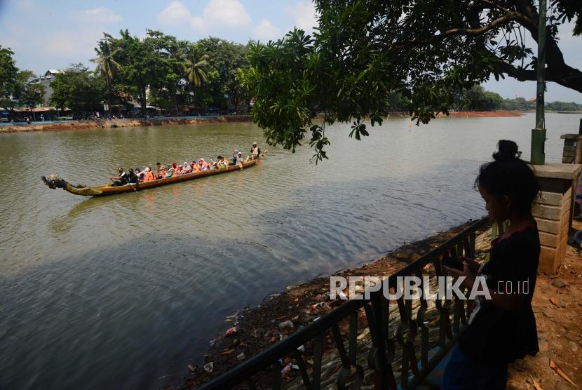 Wisatawan menikmati wahana perahu naga di kawasan Perkapungan  Budaya Betawi, Setu Babakan, Jakarta, Ahad (17/6).
