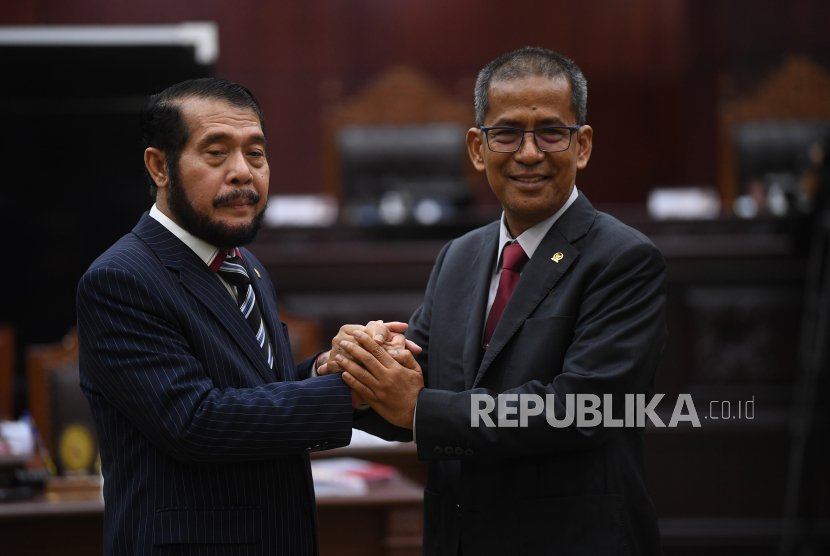 Ketua dan Wakil Ketua Mahkamah Konstitusi terpilih periode 2023-2028 Anwar Usman (kiri) dan Saldi Isra (kanan) saling berjabat tangan usai pemilihan di gedung MK, Jakarta, Rabu (15/3/2023). Anwar Usman dan Saldi Isra resmi terpilih sebagai Ketua dan Wakil Ketua Mahkamah Konstitusi periode 2023-2028 melalui mekanisme voting yang diikuti sembilan hakim konstitusi.  