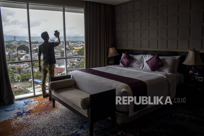 Petugas membersihkan kaca di salah satu kamar hotel di Hotel Aston Pasteur, Jalan Dr Djunjunan, Sukajadi, Kota Bandung, Rabu (28/12/2022). Perhimpunan Hotel dan Restoran Indonesia (PHRI) menyebut Bandung termasuk daerah yang tingkat okupansi hotelnya meningkat saat libur Lebaran.