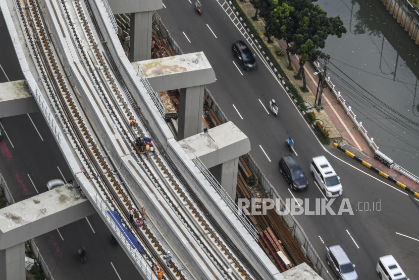 Sejumlah pekerja menyelesaikan pembangunan proyek kereta ringan (LRT) di kawasan Rasuna Said, Kuningan, jakarta, Selasa (23/2). Anak usaha PT Adhi Karya (Persero) Tbk, PT Adhi Commuter Properti, akan menerbitkan surat utang atau obligasi sebesar Rp 500 miliar. 