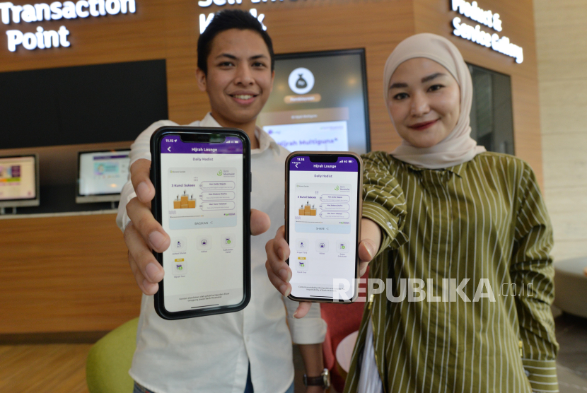 Karyawan PT Bank Muamalat Indonesia Tbk memperlihatkan fitur Hijrah Lounge di aplikasi mobile banking Muamalat DIN melalui smartphone di Jakarta, Kamis (18/1/2024). Fitur baru ini berisi konten-konten Islami seperti jadwal salat, arah kiblat, kalkulator zakat, hadis harian serta fitur Hijrah Tour yang dapat digunakan untuk melakukan pembelian paket umrah. Saat ini Muamalat DIN sudah diunduh lebih dari 500 ribu kali dengan lebih dari 480 ribu pengguna aktif. Terdapat 196 fitur di Muamalat DIN, bertambah hampir dua kali lipat dibandingkan tahun 2022 yang sebanyak 81 fitur.