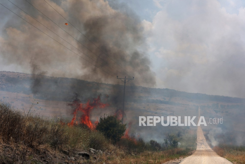 Api yang berkobar di dekat jalan usai serangan dari Lebanon, dekat Banias, di Dataran Tinggi Golan, Israel, Ahad, 09 Juni 2024. Militer Israel menyatakan pada 09 Juni, pesawat musuh memasuki Israel utara, dua pesawat udara tak berawak kendaraan (UAV) diidentifikasi menyeberang dari Lebanon. Pesawat itu jatuh di wilayah utara Dataran Tinggi Golan dan tidak ada korban luka yang dilaporkan.