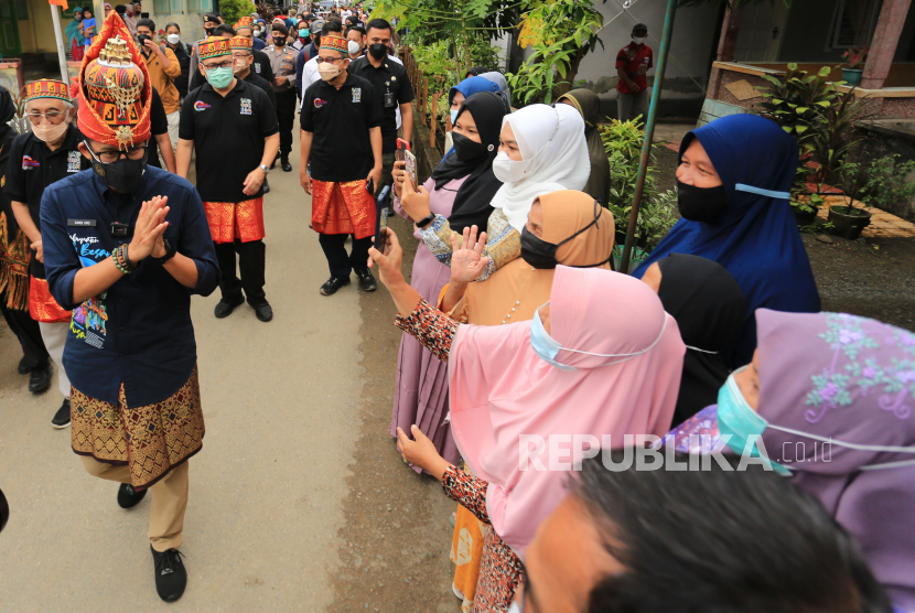 Menparekraf Sandiaga Salahuddin Uno (kiri) memberi salam dan menyapa warga saat mengunjungi Desa Gampong Nusa, Lhoknga, Aceh Besar, Aceh, Rabu (20/10). Sandiaga menegaskan, destinasi wisata halal seharusnya tidak boleh melakukan penyiksaan terhadap hewan apapun.