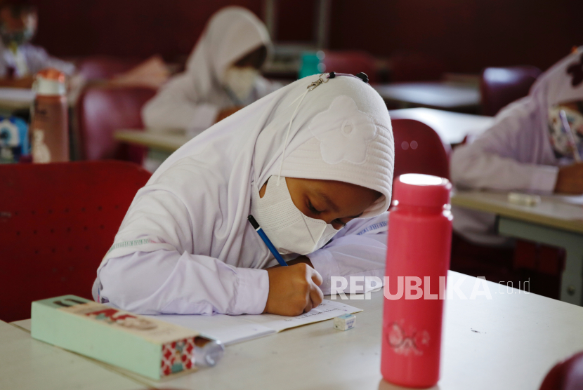 Siswa memakai masker saat belajar di kelas, ilustrasi