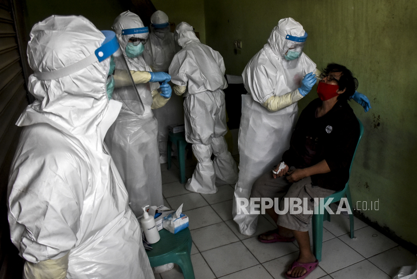 Petugas medis dari Dinas Kesehatan Kota Cimahi mengambil sampel lendir dari seorang pedagang saat tes swab Covid-19. Ilustrasi