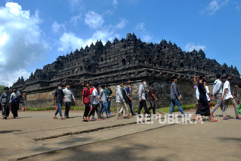 Warga berjalan-jalan saat berwisata di Candi Borobudur, Magelang, Jawa Tengah, Senin (16/5/2022). Candi Borobudur dipadati wisatawan saat Libur Hari Raya Waisak. Warga ramai berkunjung kendati diadakan acara sembahyang di Pelataran Candi Borobudur.