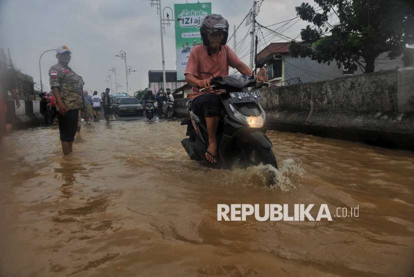 Kendaraan melintasi jalan yang tergenang banjir di Jalan raya Kalibata, Jakarta, Selasa (4/3/2025).  Banjir dari luapan Kali Ciliwung tersebut mulai menggenangi ruas jalan utama menuju dari Kalibata menuju Cililitan yang menyebabkan kondisi lalu lintas macet. Berdasarkan data BPBD DKI Jakarta mencatat, sebanyak 59 RT di kawasan Rawajati dan Cililitan terendam banjir dengan ketinggian mulai dari 30-300 centimeter yang disebabkan oleh meluapnya kali Ciliwung.