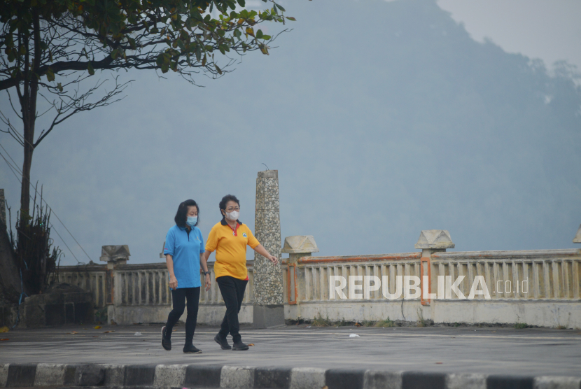Warga memakai masker saat kabut asap menyelimuti Kota Padang, Sumatera Barat, Kamis (5/10/2023). Pemkot Padang mengimbau warga untuk mengurangi kegiatan di luar ruangan, terutama kelompok rentan seperti bayi, balita, ibu hamil, dan orang lanjut usia, menyusul terjadinya penurunan kualitas udara akibat asap kiriman dari kebakaran hutan dan lahan.   