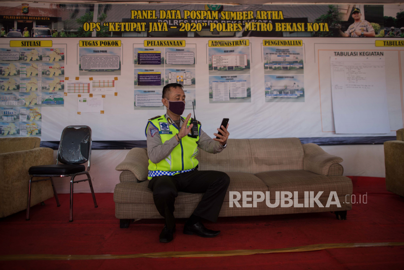 Petugas kepolisian beristirahat di posko operasi ketupat jaya pada Hari Raya Idul Fitri 1441 Hijriyah di jalur perbatasan Jakarta-Bekasi, Bekasi, Jawa Barat, Ahad (24/5). Pada Hari Raya Idul Fitri 1441 Hiriyah salah satu jalur arus mudik terpantau ramai lancar