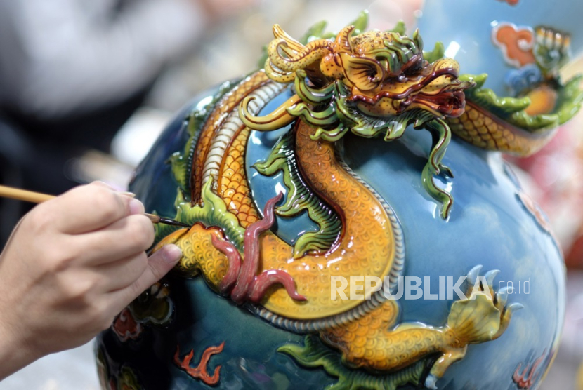 Seorang ahli keramik melukis vas yang menampilkan pola naga di Hanoi, Vietnam. 