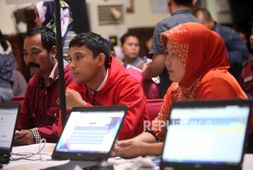 Wali murid mendaftar calon siswa didik baru secara Online diLayanan Penerimaan Peserta Didik Baru (PPDB) di SMKN 1, Jakarta, Selasa (26/6).