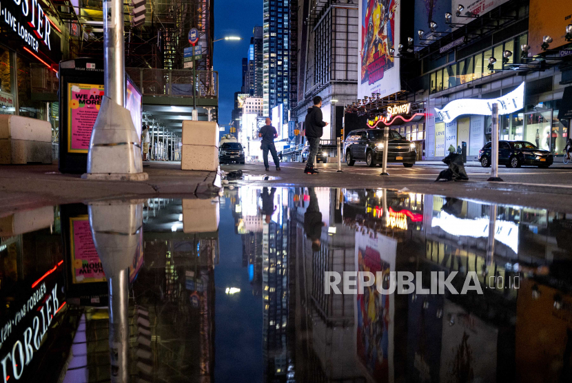 Lampu-lampu Times Square di New York tercermin dalam genangan air Kamis, 2 September 2021, saat Badai Ida tidak hanya meninggalkan air di jalan-jalan kota tetapi juga kerusakan akibat angin dan banjir parah di sepanjang pesisir Timur.