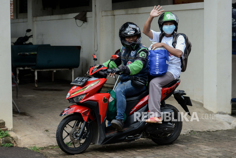 Pasien covid-19 menaiki ojek daring untuk meninggalkan tempat isolasi Graha Wisata Ragunan di Jakarta.