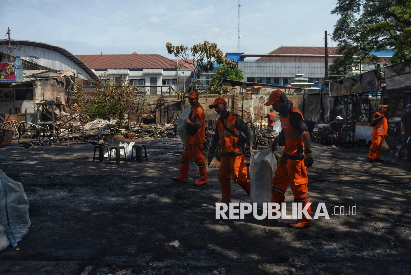PPSU membersihkan puing-puing sisa kebakaran kios pedagang pascakericuhan di kawasan Kalibata, Jakarta, Jumat (12/12/2025). Pasca kejadian tersebut, kondisi di lokasi berangsur kondusif. Setidaknya sembilan kios, enam kendaraan roda dua, dan satu kendaraan roda empat dibakar. Kericuhan ini dipicu oleh pengeroyokan terhadap penagih utang lapangan (debt collector) yang dipukuli orang tidak dikenal hingga tewas.