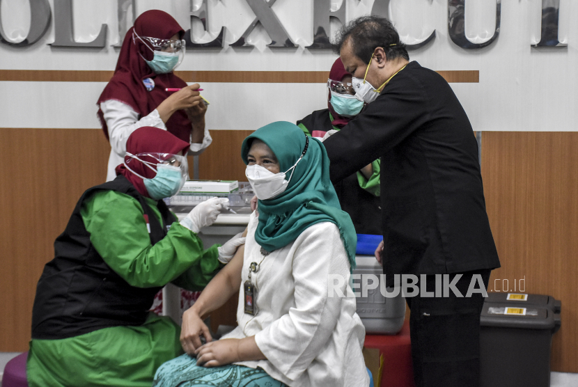 Vaksinator menyuntikkan vaksin Covid-19 Sinovac ke Kepala Dinas Kesehatan Kota Bandung Ahyani Raksanagara (kanan) di Rumah Sakit Khusus Ibu dan Anak (RSKIA), Jalan Raya Kopo, Kota Bandung, Kamis (14/1). Sekretaris Daerah Kota Bandung Ema Sumarna menjadi orang pertama di Kota Bandung yang menerima vaksinasi Covid-19 Sinovac sekaligus menandakan dimulainya program vaksinasi massal tahap pertama di sejumlah daerah di Kota Bandung yang akan berlangsung hingga April 2021 mendatang. Foto: Abdan Syakura/Republika