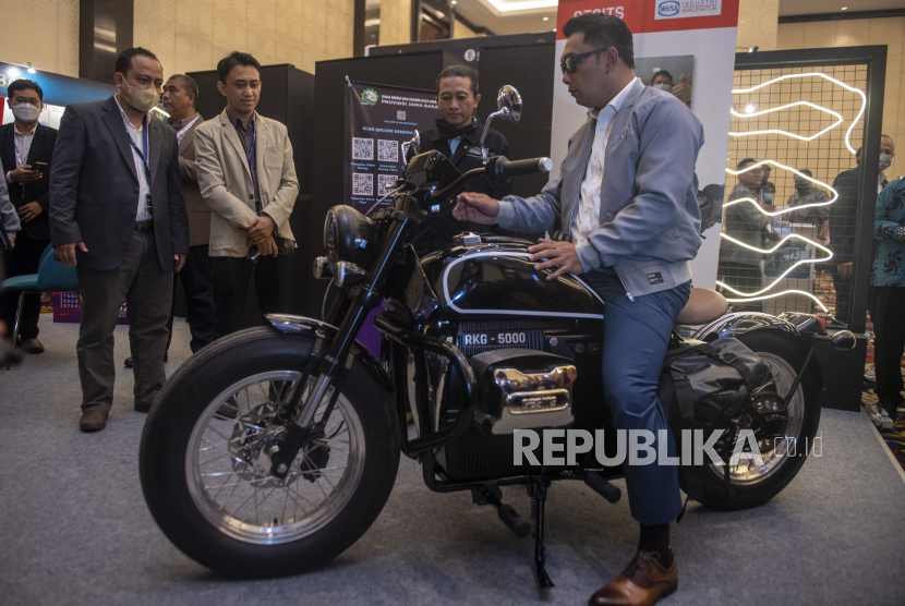 Gubernur Jawa Barat Ridwan Kamil (kanan) melihat motor listrik RKG-5000 karya desain Ridwan Kamil berkolaborasi dengan pabrikan Gesits seusai menghadiri 