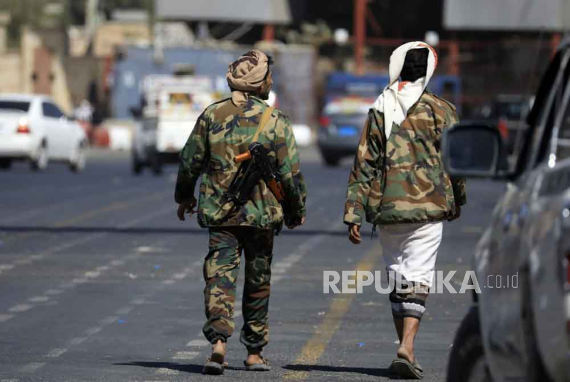 Pejuang Houthi berjalan melalui jalan di Sana