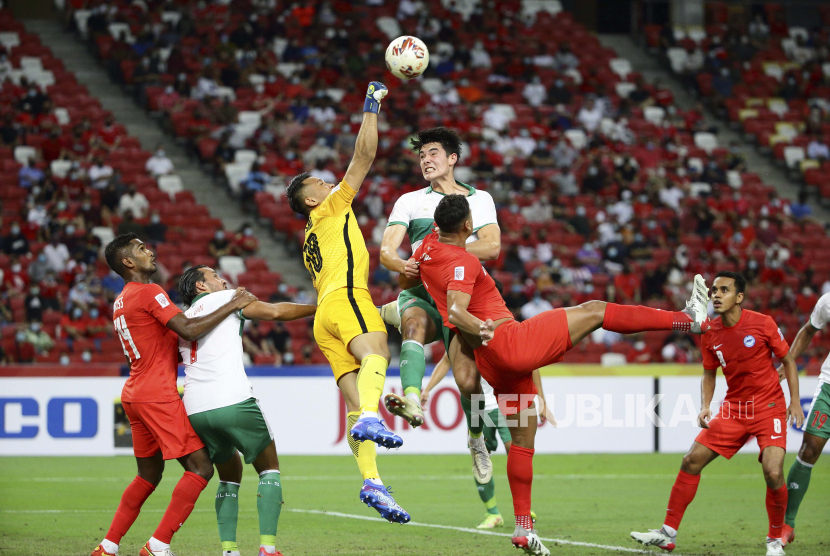  Hassan Sunny dari Singapura, ketiga kiri, dan Elkan William Tio Baggott dari Indonesia bersaing memperebutkan bola pada pertandingan sepak bola leg pertama semifinal Piala Suzuki AFF 2020 antara Singapura dan Indonesia di Singapura, Rabu, 22 Desember 2021.