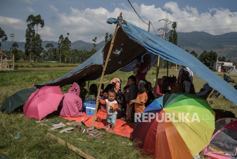 Warga mengungsi di tenda pascagempa bumi di Desa Cibeureum, Kertasari, Kabupaten Bandung, Jawa Barat, Rabu (18/9/2024). Menurut data sementara BPBD Provinsi Jawa Barat, sebanyak 450 warga terpaksa mengungsi, 58 orang luka ringan dan 23 lainnya luka berat dari tiga desa yang terdampak gempa bumi berkekuatan Magnitudo 5,0. 