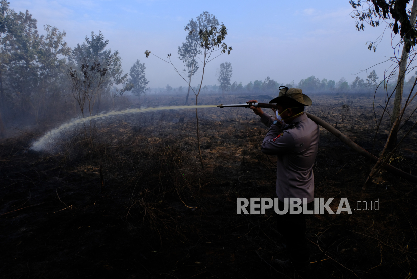 Petugas melakukan pembasahan di lokasi kebakaran lahan gambut di Kalimantan Timur (ilustrasi). BMKG menyebut titik panas di Kalimantan Timur turun signifikan.  