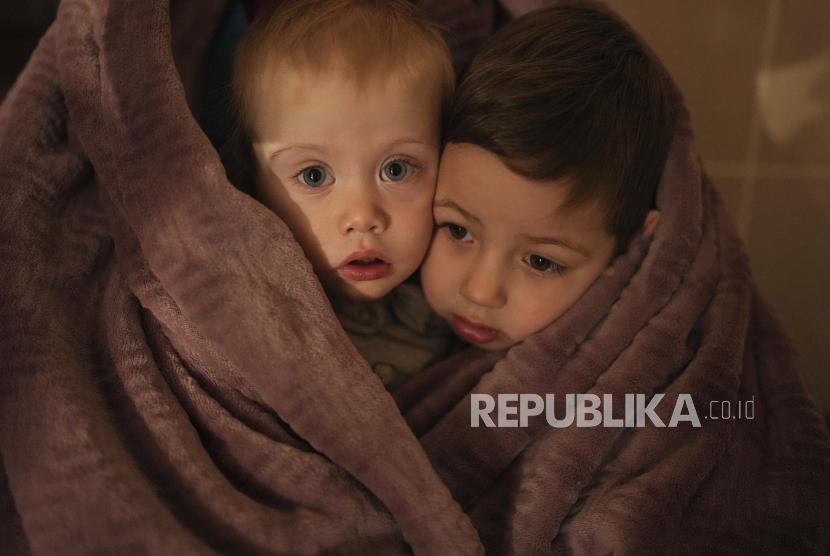 Andy Murray Bantu Anak-Anak Ukraina. Foto: Anak-anak pekerja medis menghangatkan diri dalam selimut saat menunggu kerabat mereka di sebuah rumah sakit di Mariupol, Ukraina, Jumat, 4 Maret 2022.